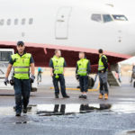 Baggage Claim workers with jet airplane at airport to improve passenger experience