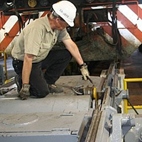 Locomotive mechanic performing maintenance on locomotive rail equipment
