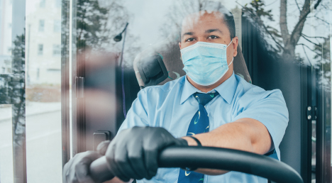 Bus driver wearing a face mask and rubber gloves