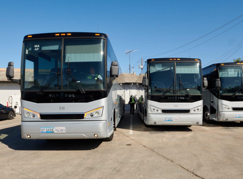A fleet of Hallcon buses at an EV charging terminal.