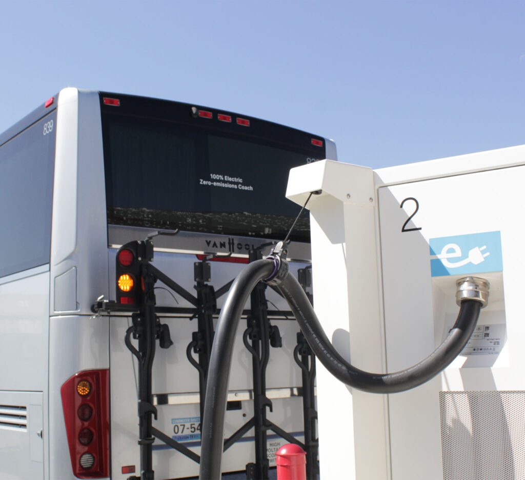 A Hallcon electric bus charging from behind.