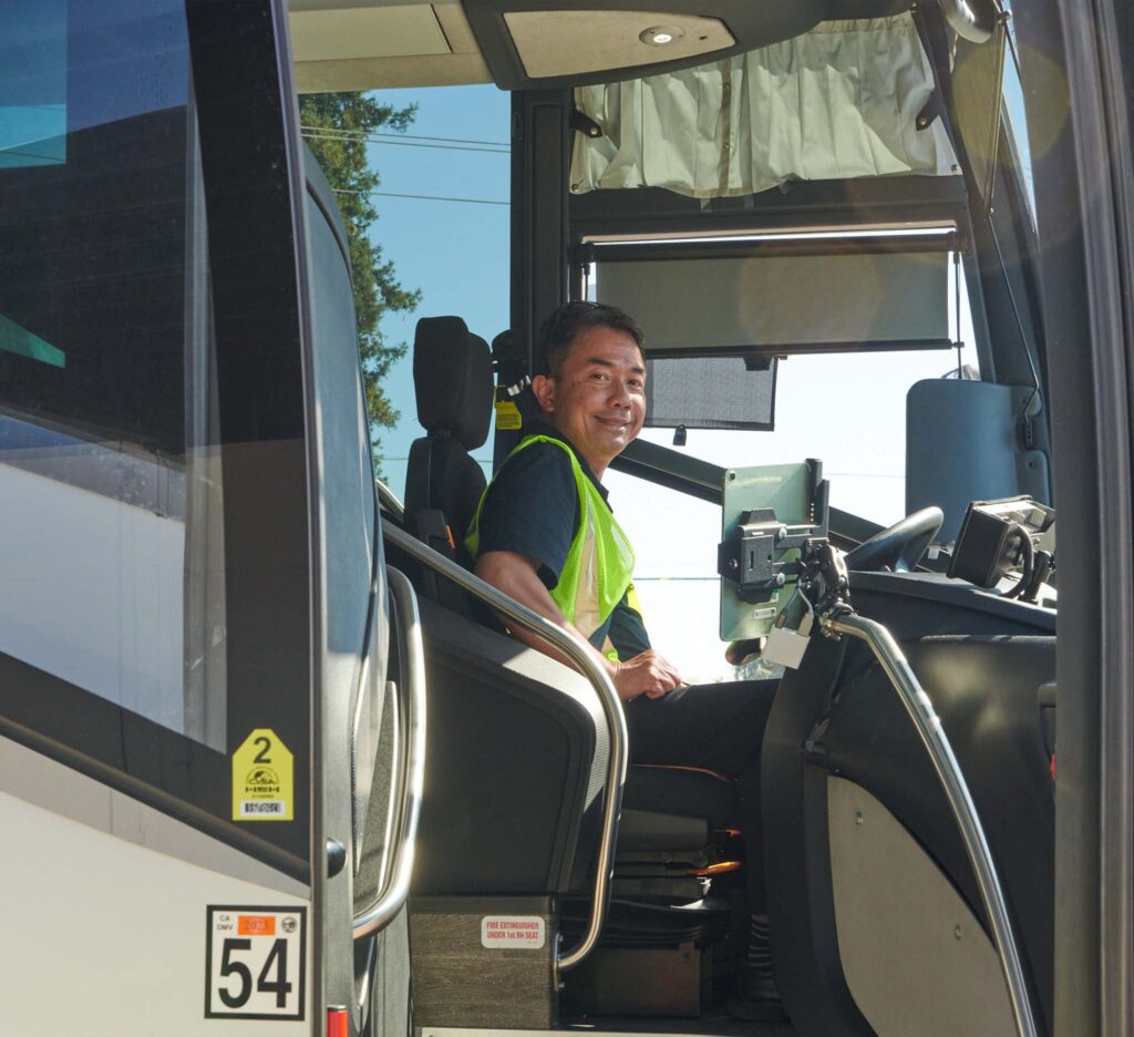Hallcon bus driver sitting in the front seat, ready to drive.