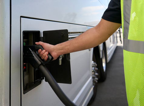 Hallcon team member charging motorcoach bus