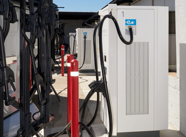 EV motorcoach parked in front of an EV charger.